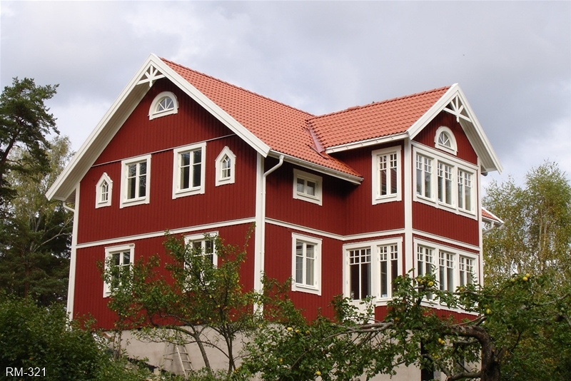 Rött hus med vita knutar och vacker veranda i två plan.
