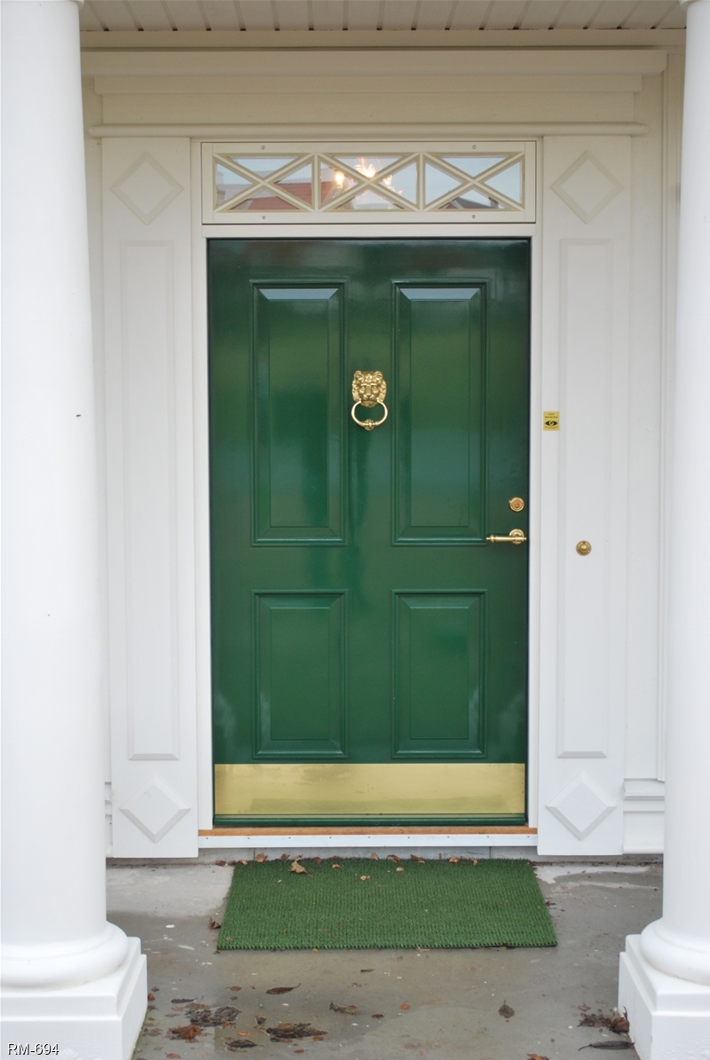 Inåtgående enkeldörr med grön utsida och överljus med krysspröjs